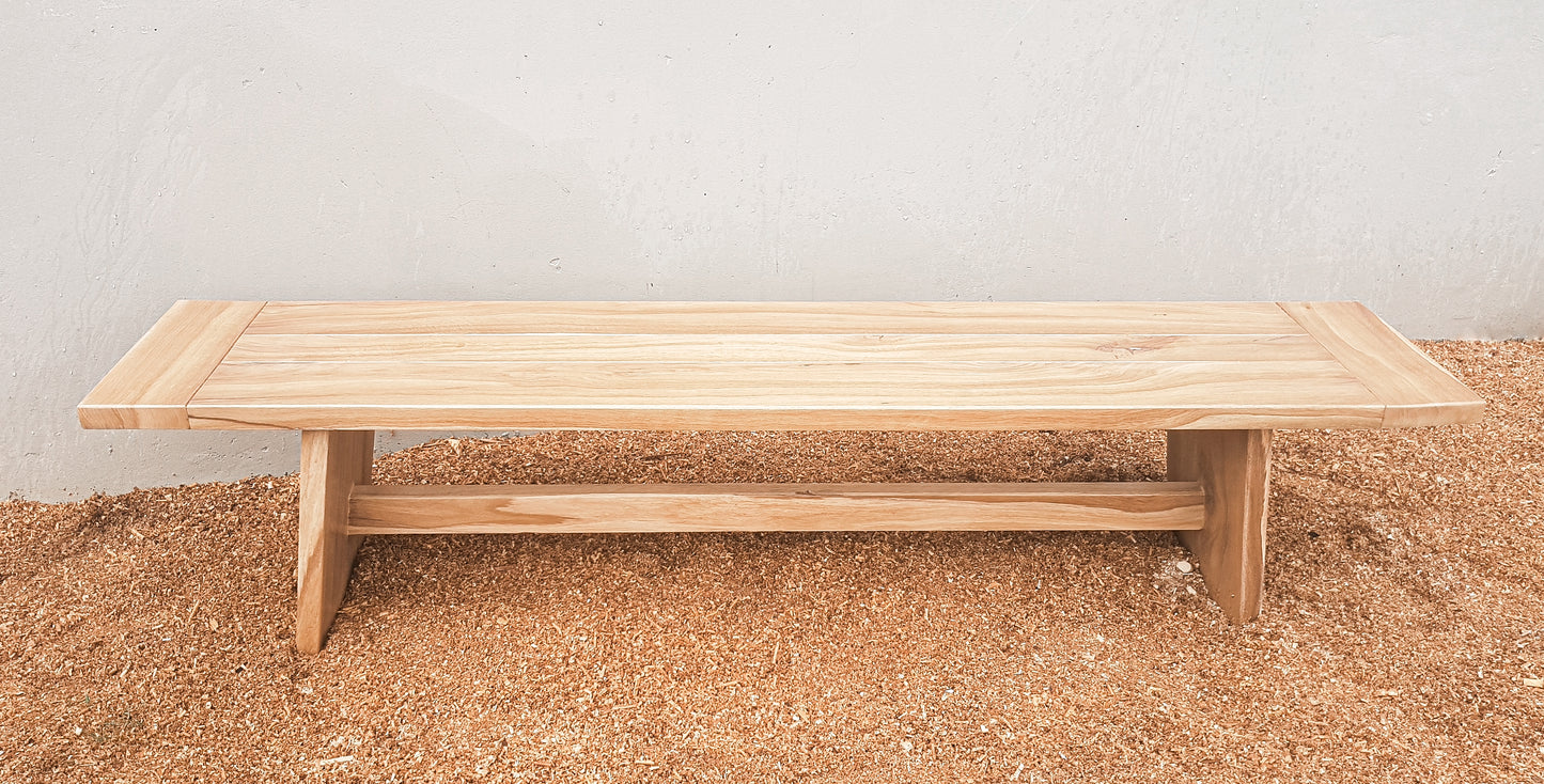 A handmade solid wood bench with a simple, modern design.